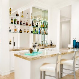 Expansive Decadent Waterfront open concept, wet bar, marble kitchen, glass shelves, neutral colors, bar stools