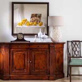 A still life painting hung above this mahogany antique wood credenza.