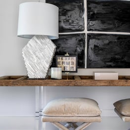 Portfolio: Elegant seating area featuring neutral toned furnishings and a geometric lamp.