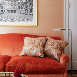 Detail shot of orange sofa, orange wallpaper in sitting room