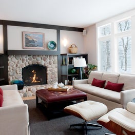 Lake Michigan Family Room. Stone fireplace with built ins & a lake view. Linen sofas with Eames Chair.
