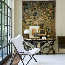 At Home sitting area with modern chair and tapestry