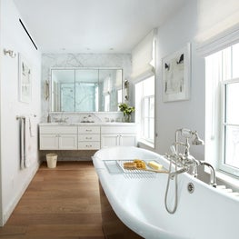 Bright bathroom complete with free standing tub and marble accents 