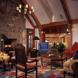 This stone fireplace is balanced by a colorful carpet and a range of furniture.