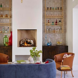 Custom Bars Flank a Fireplace, with a Luxe Seating Area Beyond