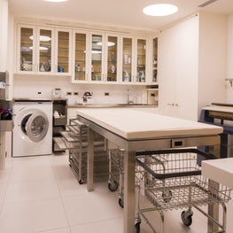The utilitarian, organized white laundry room has storage for everything.