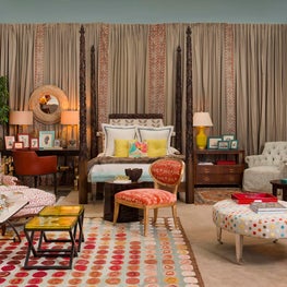 A custom carved bed with contemporary art accents in our vignette 