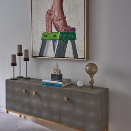 Grey credenza with gold detail, topped with contemporary sculpture & pop art