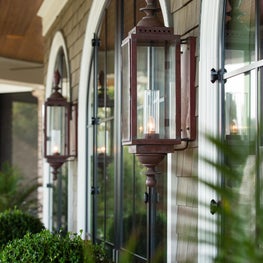 Elliptical Steel French Doors and Shingled Wall with Copper Outdoor Sconces