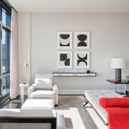 NYC Living Room, modern furnishings, grey and white palette with pops of red.