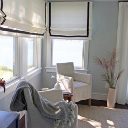 Ocean front bedroom sitting area w navy trimmed linen roman shades