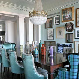 Eclectic dining room with columns, gallery wall & antique chandelier