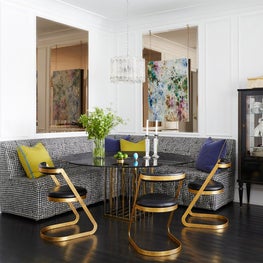 Glamorous breakfast area with banquette and gold Art Deco chairs