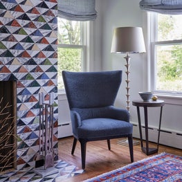 Kenilworth Living Room. Blue fireplace chair with oriental rug, modern floor lamp & eclectic tile fireplace.