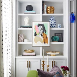 Shelf detail with artwork and green sofa