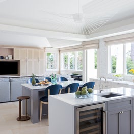 Portfolio: A modern white kitchen with dual islands and blue counter stools in Pebble Beach, CA.