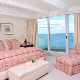 This stylish pink transitional bedroom blends well with the ocean view.