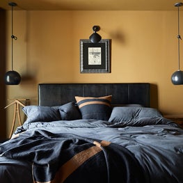 Smart and cozy bedroom design for a batchelor in hues of camel and black.