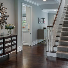 Welcoming Foyer with Eclectic Accents plays off of Tailored Pinstriped Stair Runner