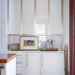 White laminated glass cabinets with nickel edging & Royal Danby marble counters