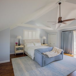 Modern and calm Hamptons bedroom in tones of blue and vaulted ceiling.