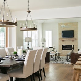 This contemporary, neutral open plan features twin rustic lighting fixtures.