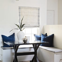 Light filled breakfast nook with bench seating and contemporary light fixture.
