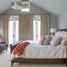 Large guest bedroom with orange and red accents