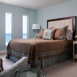 The dark wood bed frame in the master bedroom  contrasts the softer blue tones. 