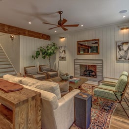 Shiplap walls with concealed storage provided on either side of the fireplace