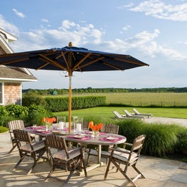 Hamptons Farmhouse patios, outdoor dining under an umbrella, pool furniture