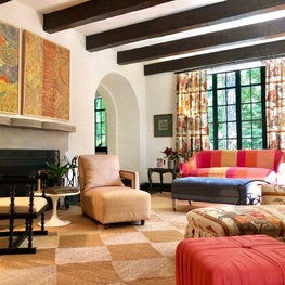 The Spanish Colonial architecture sets a chic backdrop for a fun and comfortable space featuring vibrant art, lush upholstery, and festive textiles by Jim Thompson and Fortuny.