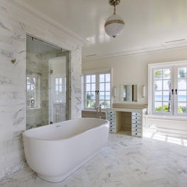 An oceanfront bathroom rendered in Calacatta Gold Marble