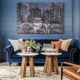 Eclectic office area living room lounge with blue velvet sofa and leather chair