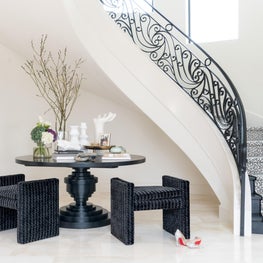 Portfolio: Sophisticated seating arrangement in foyer next to glamorous staircase 