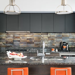 View into the kitchen, with custom stools and lighting