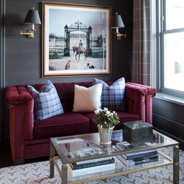 Sitting room with black walls, burgundy velvet sofa