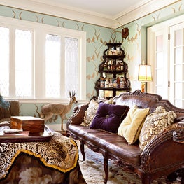 Gentleman’s bar and library with hand stenciled walls, antiques, taxidermy, and layered rugs and fabrics by JIM THOMPSON.