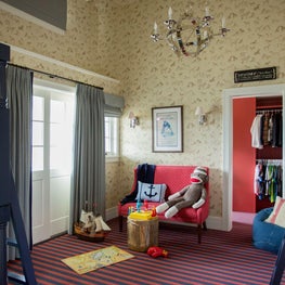 Kid's room with fun wallpaper and striped floors, chandelier