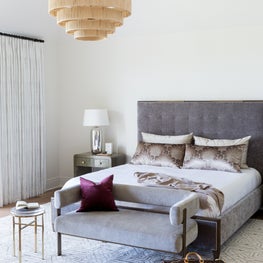 Portfolio: The master suite at a Pebble Beach, CA home with an Everly Pendant chandelier and upholstered furnishings.