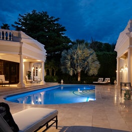 The turquoise water of the pool contrasts with the new tumbled-marble pool deck.