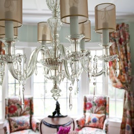 Kenilworth Dining Room. Antique chandelier with modern shades & floral upholstered hostess chairs.