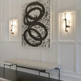 Paneled hallway with cast bench