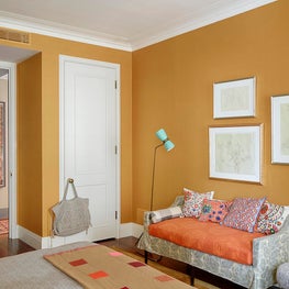 A customized wall treatment using silk Taffard fabric in a rich shade of gold