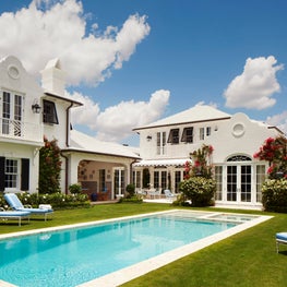 The garden and rear facade of a Bermudian Colonial house in Palm Beach