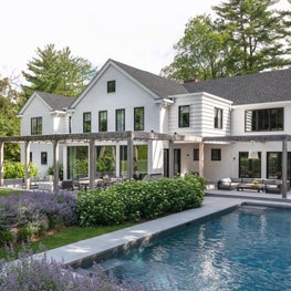 Farmhouse modern renovation with terraced patio and cedar trellis
