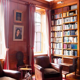 Classic Library with wood paneled walls and floor-to-ceiling bookshelves