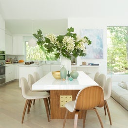 East Hampton Residence - white glass dining table with walnut & brass base.