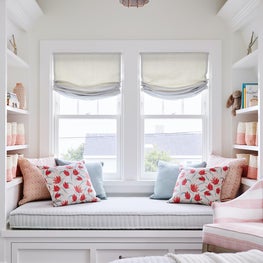 Girls bedroom with built-in window seat and trundle and bookcases in pink and aqua