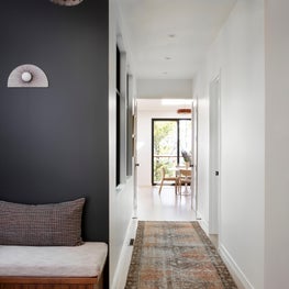 Hallway with eclectic lighting, built-in banquette, and runner